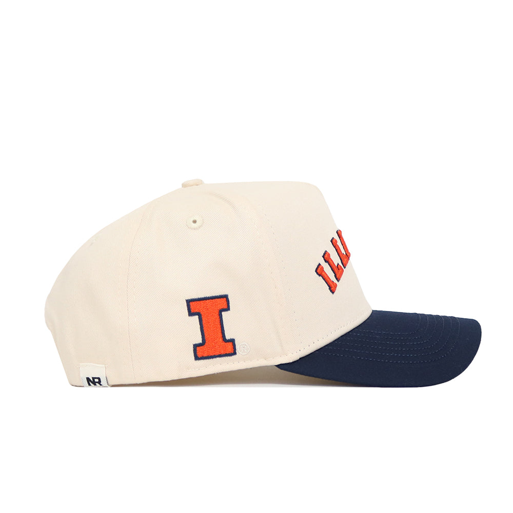 The Right Side Up Illinois Hat by No Rivals is a cream baseball cap with a dark blue brim, an orange and navy "I" logo on the side, and "ILL" embroidered in orange on the front. Made from high-quality cotton.