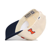 The Right Side Up Illinois Hat by No Rivals is a cream snapback with a navy bill, a bold orange “I” on the side, and “NO RIVALS” on the inner band. Made from high-quality cotton, its structured fit highlights interior details.