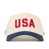 No Rivals USA Vintage Hat - 5 Panel Structured in cream with a dark blue brim, featuring red USA embroidery and a small American flag tag on the side.