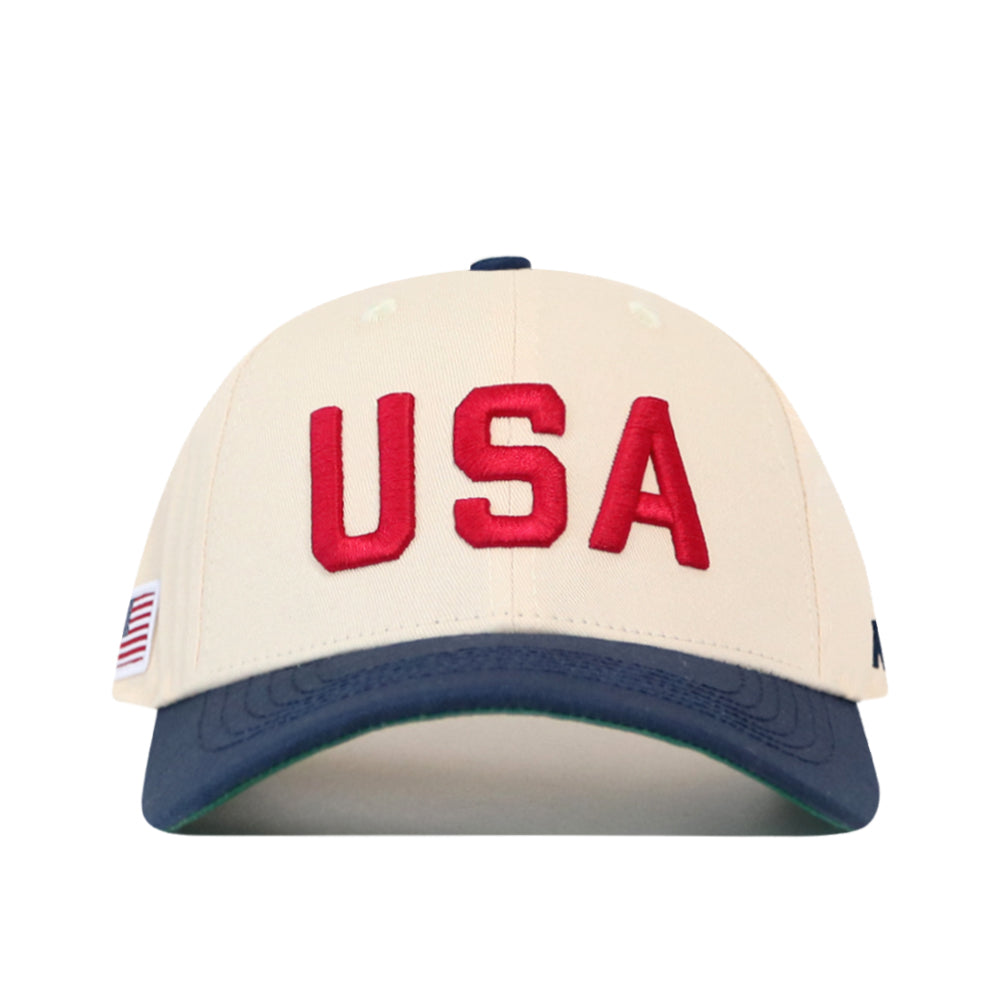 USA Vintage Hat - 6 Panel Structured in off-white cotton with USA embroidered in red letters, a navy blue brim, and a small American flag patch on the side.
