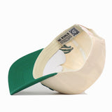 Rear view of the cream-colored USF Halftime Hat with a green brim, showing the interior No Rivals brand label and a QR code.