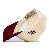 Rear view of a cream-colored Texas A&M Bear Hat - 5 Panel Structured with a maroon brim, featuring an A&M logo on the side and embroidered graphics.