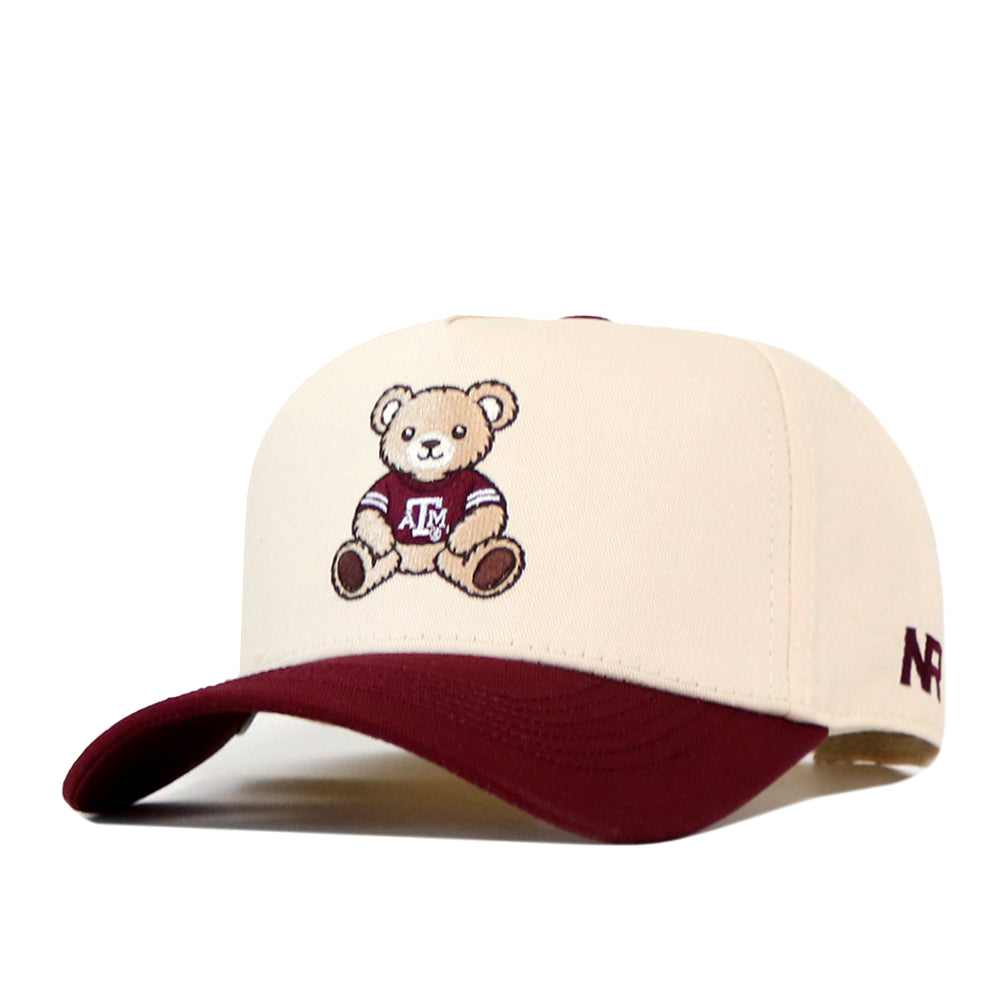 Cream-colored Texas A&M Bear Hat - 5 Panel Structured featuring a maroon brim and an embroidered teddy bear wearing a university jersey.