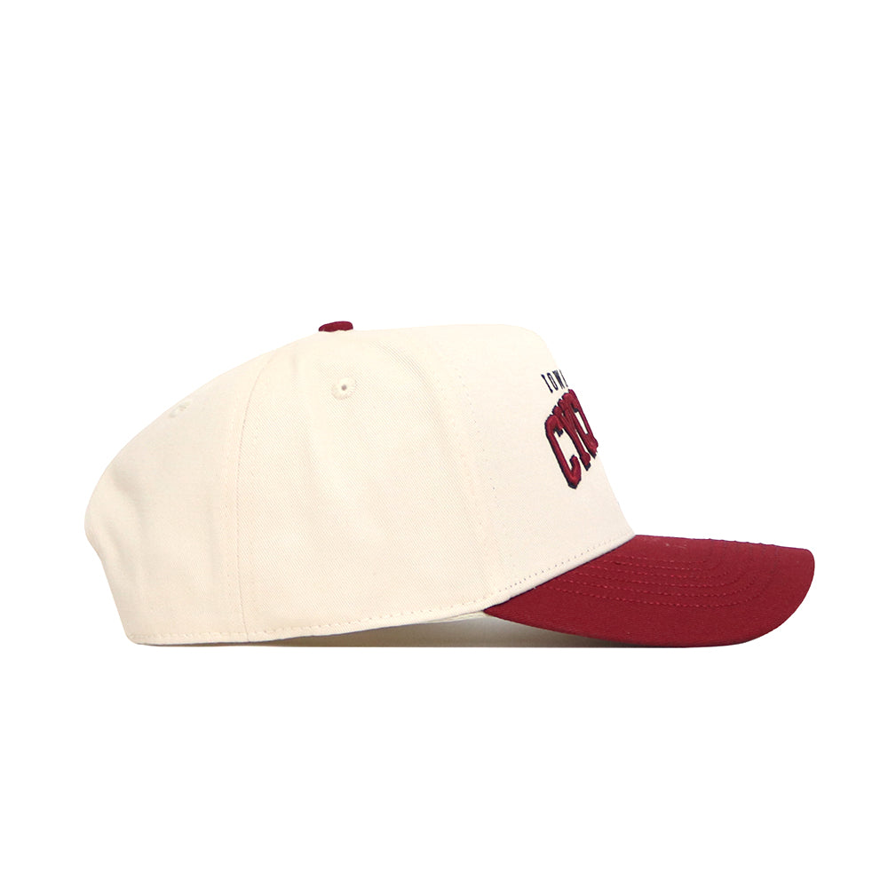 A side view of the No Rivals Iowa State Arch Hat, featuring a cream crown, maroon brim, high-quality cotton construction, and embroidered front text.