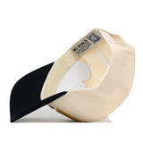 Side view of a two-tone Vanderbilt Stride Hat, showing the interior labels and a QR code on the sweatband.