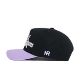 The No Rivals ECU Dugout Collection Hat - Powder Purple features a black cotton build, light purple brim, white "NR" embroidery on the side, plus white and yellow embroidery on the front for a structured, premium look.