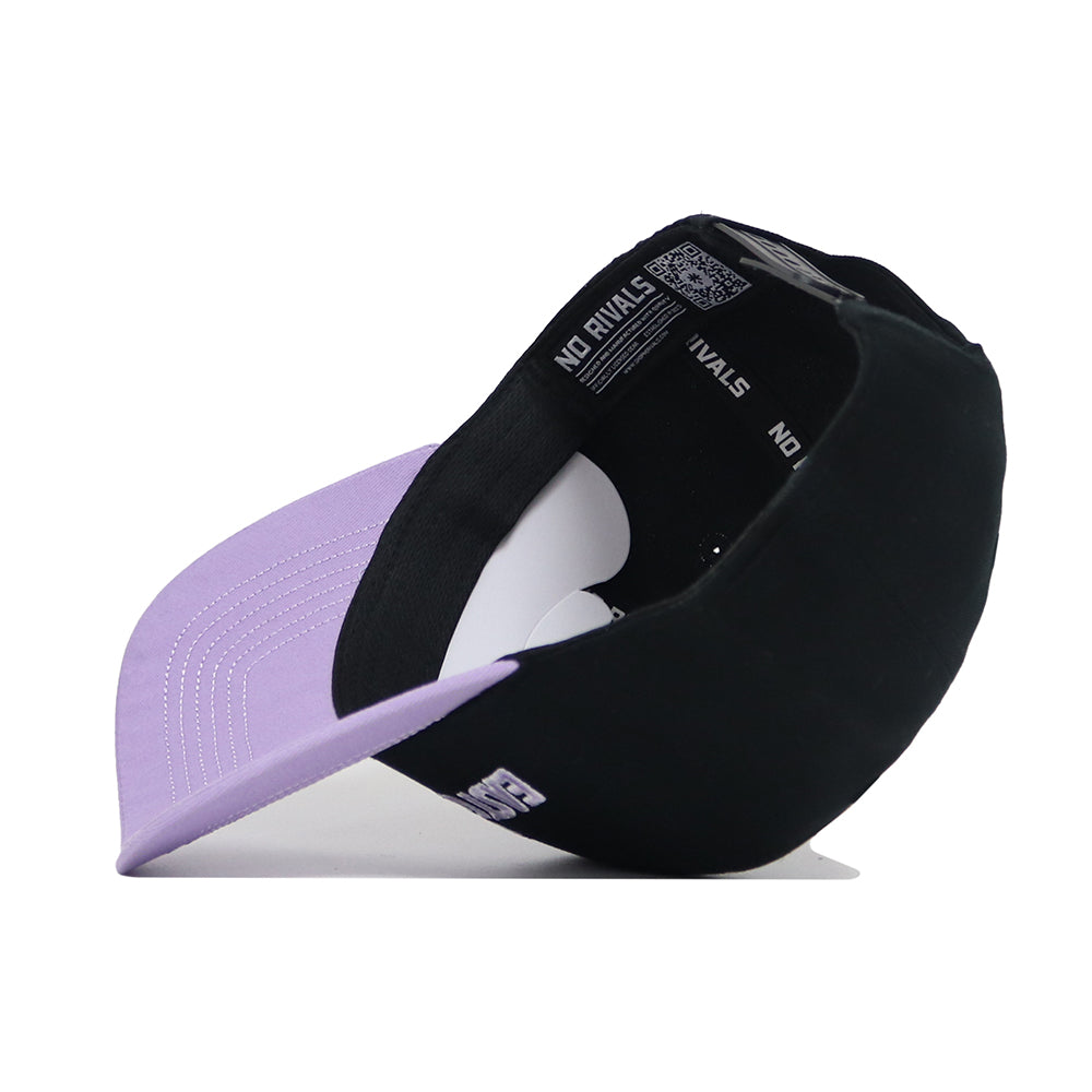 The ECU Dugout Collection Hat - Powder Purple by No Rivals is pictured upside down, revealing its lavender brim underside, inner lining, and "NO RIVALS" branding on the inside band. Crafted from high-quality cotton.