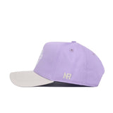 The ECU Closer Hat - Powder Purple by No Rivals features a lavender cotton design with a light beige brim and white "NR" initials embroidered on the side, shown in profile against a white background.