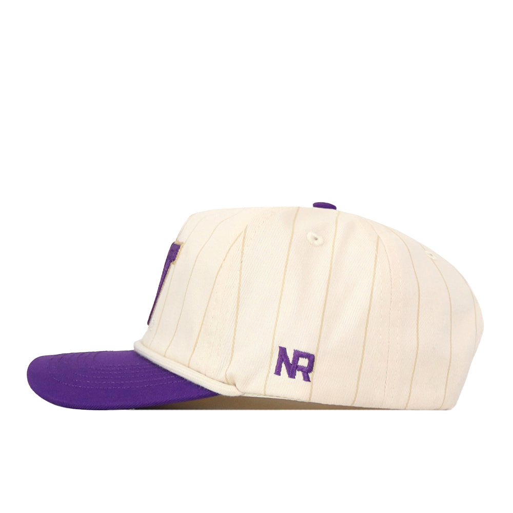 The No Rivals Washington Pinstripe Hat is a cream-colored snapback baseball cap featuring subtle vertical stripes, a purple brim, and the letters “NR” embroidered in purple on the side. This cap showcases an embroidered logo for both style and comfort.