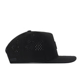 The No Rivals Michigan State Spartans Trainer Hat is a black snap back hat featuring a flat brim and small perforations on the side panels, crafted from high-quality cotton for durability and comfort. It is shown from the side on a white background.