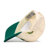The Right Side Up Bison Hat - Classic by No Rivals is shown inside out, displaying a QR code and the words “NO RIVALS” on the inner band. This cream and green snapback features a green brim, with part of its officially licensed yellow and green embroidered logo visible.