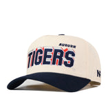 Show your Auburn spirit with the No Rivals Auburn Alma Mater Hat—a cream-colored snapback featuring a dark blue brim and finely embroidered logos for a polished finish. The front proudly displays “AUBURN” above bold “TIGERS” lettering, representing the Auburn Tigers. The perfect hat to complete your gameday outfit.
