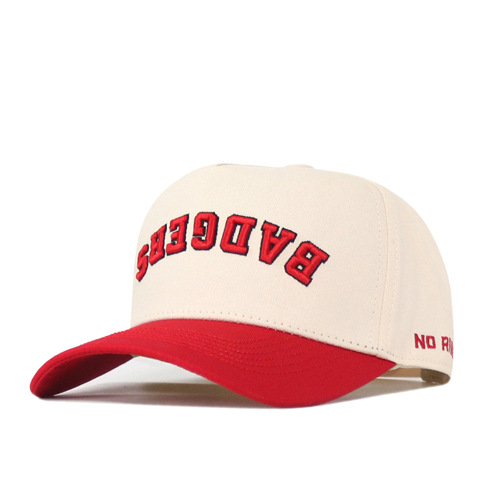 Stand out in the Wisconsin Badgers Upside Down Badgers Hat - Classic by No Rivals. This beige and red snapback features “BADGERS” embroidered upside down in bold red letters across the front and “NO” subtly stitched in small red text on the side of the brim, offering a playful twist for any fan looking to make a statement.