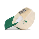 The Right Side Up Bulls Hat - USF - Classic by No Rivals is a cream-colored cotton baseball cap with a green bill, green side logo embroidery, and an internal fabric tag reading "NO RIVALS," shown upside down to display the interior.