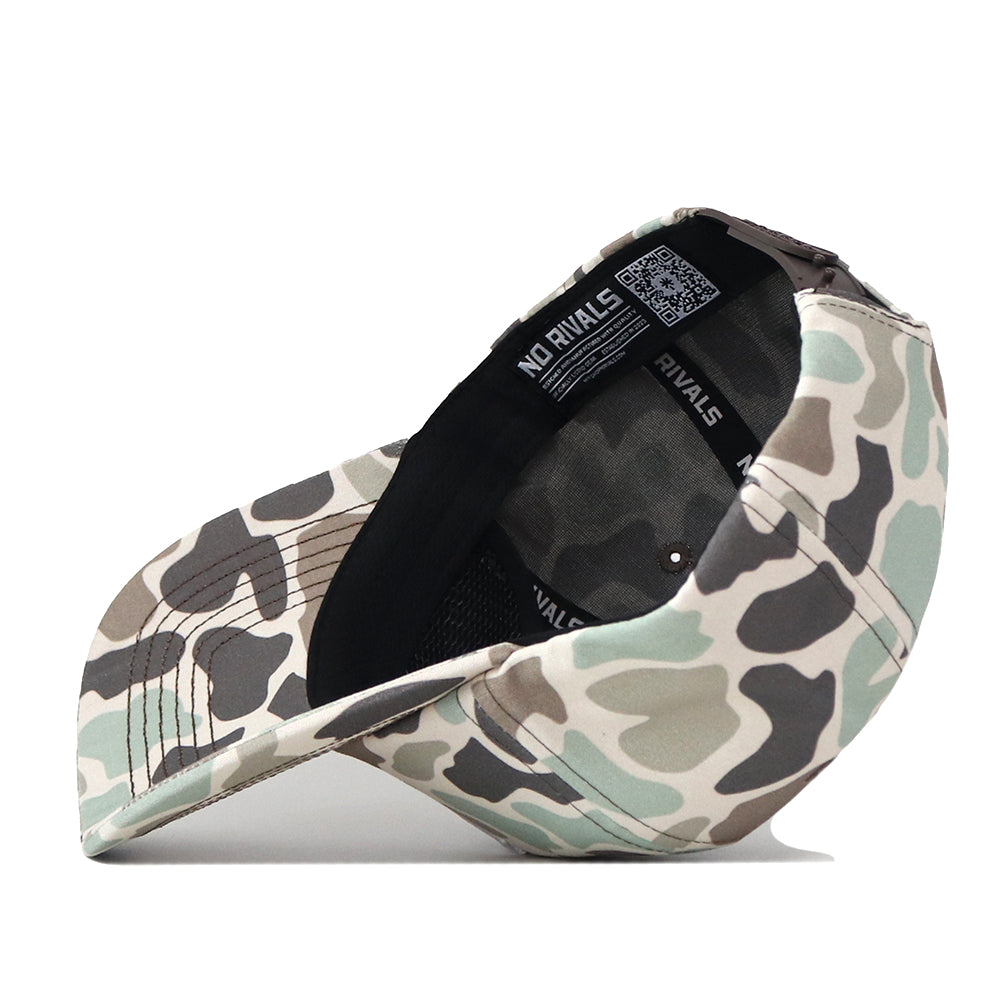 The WVU Mountaineers Huntsman Hat by No Rivals is a camouflage-patterned snapback cap crafted from high-quality cotton. Shown upside down, the cap reveals its black inner band and an interior label bearing the No Rivals brand name. Featuring various shades of green, beige, and gray in a classic camo print, this hat offers a structured fit for lasting comfort and style.
