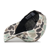 The WVU Mountaineers Huntsman Hat by No Rivals is a camouflage-patterned snapback cap crafted from high-quality cotton. Shown upside down, the cap reveals its black inner band and an interior label bearing the No Rivals brand name. Featuring various shades of green, beige, and gray in a classic camo print, this hat offers a structured fit for lasting comfort and style.