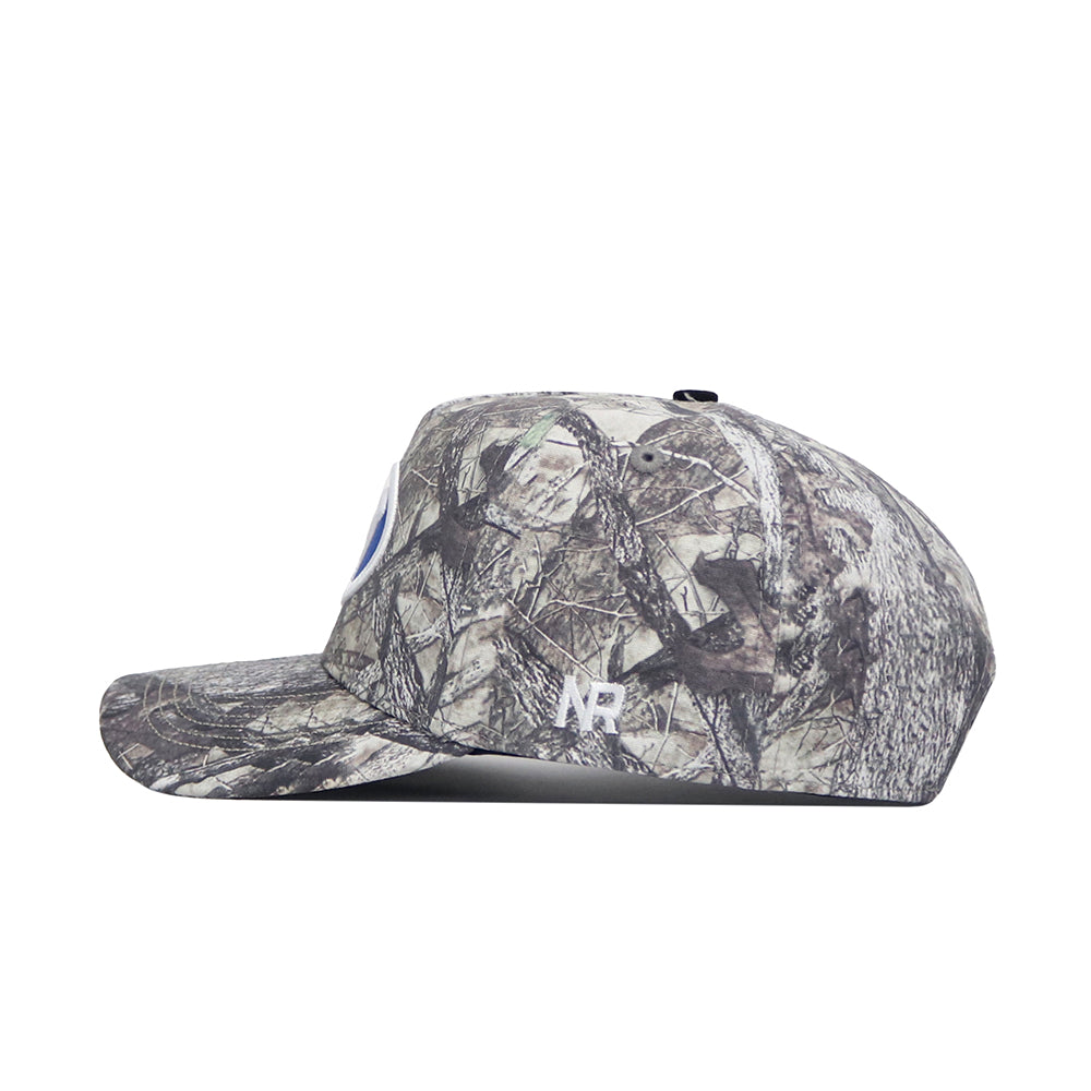 The No Rivals BYU Outland Hat is a structured fit camo baseball cap with a forest pattern, side view, embroidered white NB logo near the brim, and crafted from high-quality cotton.