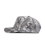 The No Rivals BYU Outland Hat is a structured fit camo baseball cap with a forest pattern, side view, embroidered white NB logo near the brim, and crafted from high-quality cotton.