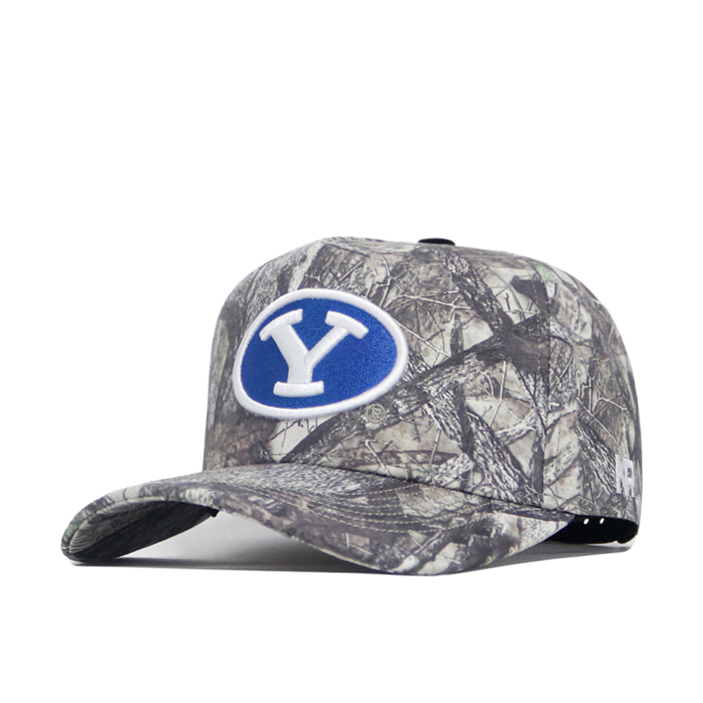 The BYU Outland Hat by No Rivals is a camouflage baseball cap with a blue oval patch and white Y on the front. Made from premium cotton, it features a structured fit, curved brim, and adjustable back strap.