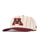 The No Rivals Minnesota Gopher Pinstripe Hat boasts a cream base with thin maroon pinstripes, a bold embroidered maroon and gold “M” on the front, and a maroon brim—making this snapback the perfect addition to your gameday fit.