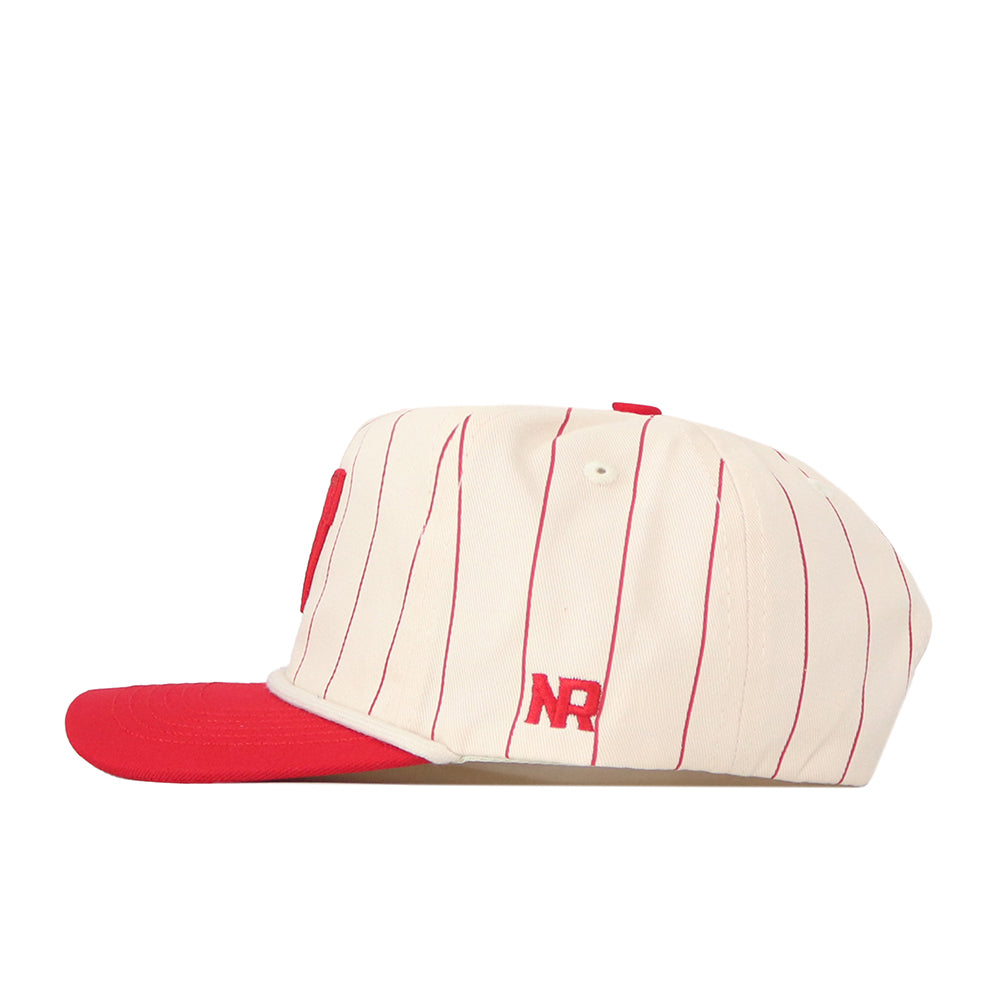 Side view of the No Rivals Wisconsin Pinstripe Hat, a cream-colored baseball cap with thin red vertical stripes, a solid red brim, and the letters “NR” stitched in red on the side, featuring a snap back adjustment for a comfortable fit.