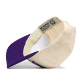 The ECU Pirates Stride Hat by No Rivals is pictured from the inside, highlighting the brand label on the inner band and a QR code near the back. Subtle embroidered logos enhance this standout cream and purple snapback with a premium touch.