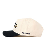 Introducing the Right Side Up Rams Hat - VCU - Classic by No Rivals. This stylish snapback features a cream-colored crown, a contrasting black brim, and “NO RIVALS” embroidered in dark blue on the side. The front showcases a partially visible embroidered logo, making it the perfect accessory to complete your game day look.