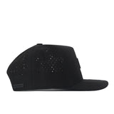 Side view of the Georgia Bulldogs Trainer Hat by No Rivals, a black flat-brimmed snapback featuring small perforated holes on the crown for ventilation and a subtle black label near the back edge, crafted from high-quality cotton for a structured fit.