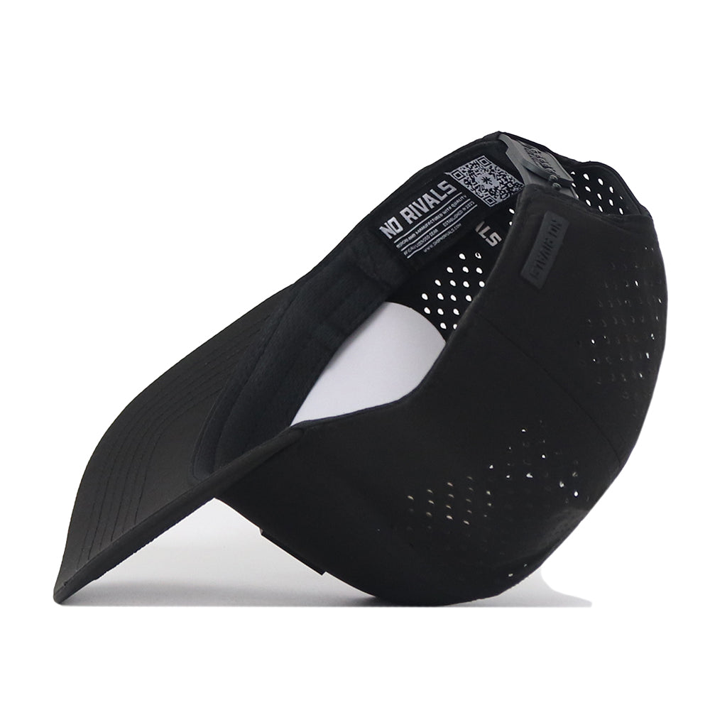 The South Carolina Gamecocks Trainer Hat by No Rivals is displayed from the side, showcasing its perforated black design. The inside label features the No Rivals branding. This structured snapback hat is made from high-quality cotton for a comfortable fit, and includes a curved bill and adjustable strap for added style and versatility.