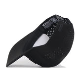 The South Carolina Gamecocks Trainer Hat by No Rivals is displayed from the side, showcasing its perforated black design. The inside label features the No Rivals branding. This structured snapback hat is made from high-quality cotton for a comfortable fit, and includes a curved bill and adjustable strap for added style and versatility.