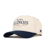 The No Rivals University of Illinois Vintage Hat is a beige and navy structured cap made from premium cotton, featuring "EST 1876 ILLINOIS Fighting Illini" embroidery on the front and "NF" stitched on the side.