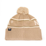 The Nebraska Cornhuskers Desert Beanie by No Rivals features a tan knit design with white and olive green stripes, a pom-pom on top, and an officially licensed NR embroidered logo on the front cuff. Made from high-quality cotton for lasting comfort and durability.