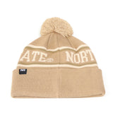 Stay warm and stylish on game day with the North Dakota State Bison Desert Beanie by No Rivals. This tan knit beanie features white stripes, a playful pom-pom on top, STATE and NORTH lettering, a folded brim, and an embroidered logo patch on the front—making it the perfect finishing touch for your gameday outfit.