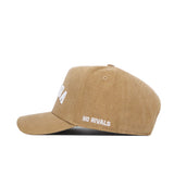 The Nevada Rustic Hat by No Rivals is a tan cotton canvas hat featuring “NO RIVALS” embroidered in white on the side, shown in side profile against a white background. This structured fit delivers both style and comfort.