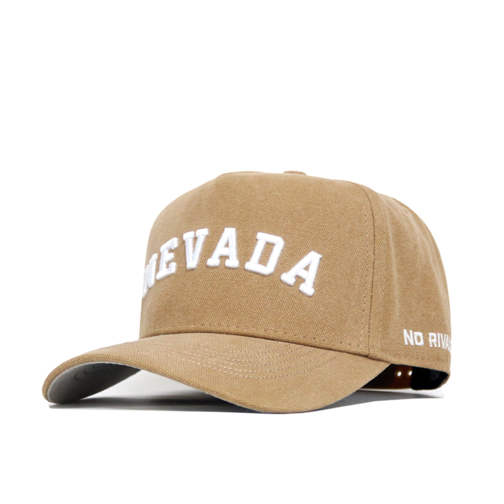 The Nevada Rustic Hat by No Rivals is a tan cotton canvas hat featuring "NEVADA" embroidered in white on the front and "NO RIVALS" stitched on the brim, offering structured fit, classic style, and comfort.