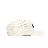 Side view of the No Rivals Golf Hat - Tan by No Rivals, an off-white snapback cap with black vents, flat brim, and a small black embroidered logo on the front. Displayed on a white background—ideal for your gameday fit.