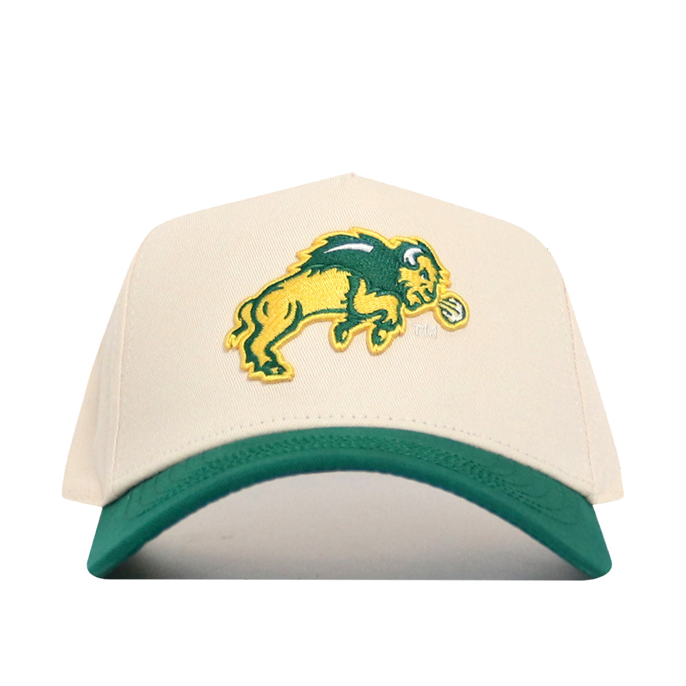 The No Rivals NDSU Logo Patch Hat is a beige snapback with a green bill, made from premium cotton and features an embroidered yellow and green buffalo holding a tennis ball on the front.