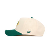 Side view of the NDSU Logo Patch Hat by No Rivals—a cream snapback with green brim, high quality cotton, green embroidered NR on the side, and a colorful patch logo on the front.