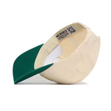 The NDSU Logo Patch Hat by No Rivals is shown upside down, displaying its inside label, QR code, and adjustable strap—all crafted from high-quality cotton for comfort and style.