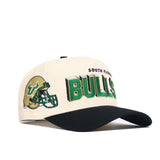 The No Rivals USF Alma Mater Collection cap features cream cotton, a black brim, and an embroidered green and gold football helmet with “South Florida Bulls” on the front. This officially licensed snapback is perfect for fans.