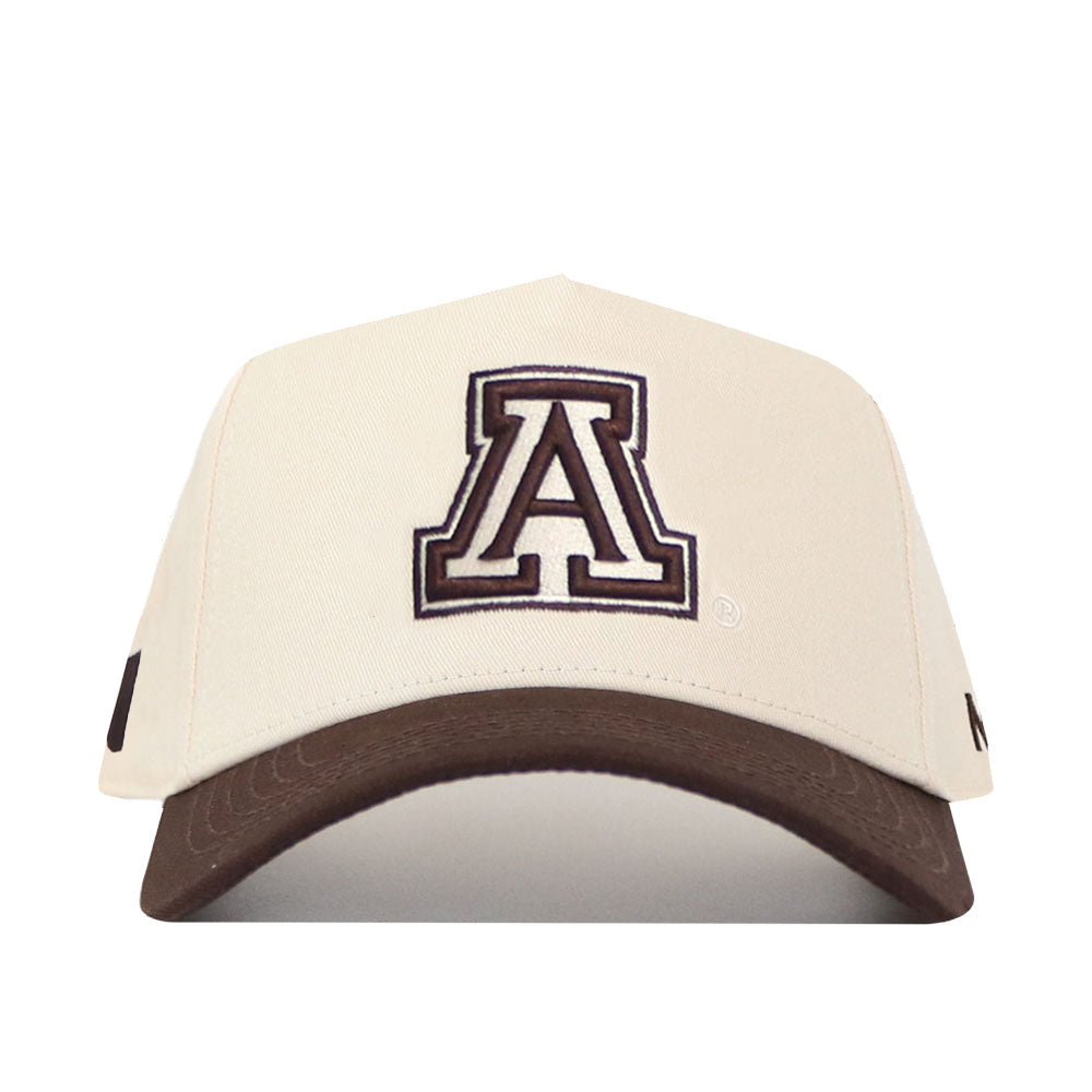 The Arizona Espresso Hat by No Rivals is a structured fit baseball cap in high-quality beige cotton, featuring a brown brim and a large embroidered A, outlined in black and white, on the front.