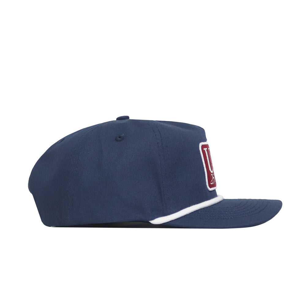 Side view of the No Rivals USA Land of the Free Patch Hat in navy blue, featuring a white trim above the brim and a partially visible red and white patch on the front.
