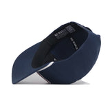 A navy blue USA Land of the Free Patch Hat by No Rivals is shown from a side angle with the inside visible. "NO RIVALS" is printed in white on the inner band, and there's a QR code inside this structured snapback cap.