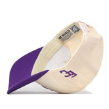The No Rivals ECU Vintage Patch Hat is flipped upside down, revealing a purple brim and cream crown with bold embroidered logos and visible interior tags—perfect for your next gameday fit.