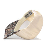 The No Rivals Auburn Camo Connector Hat is pictured upside down, revealing the inside label and detailed stitching. Its brim showcases a woodland camo pattern, while the visible fabric and construction highlights make it a standout choice for your perfect gameday fit.