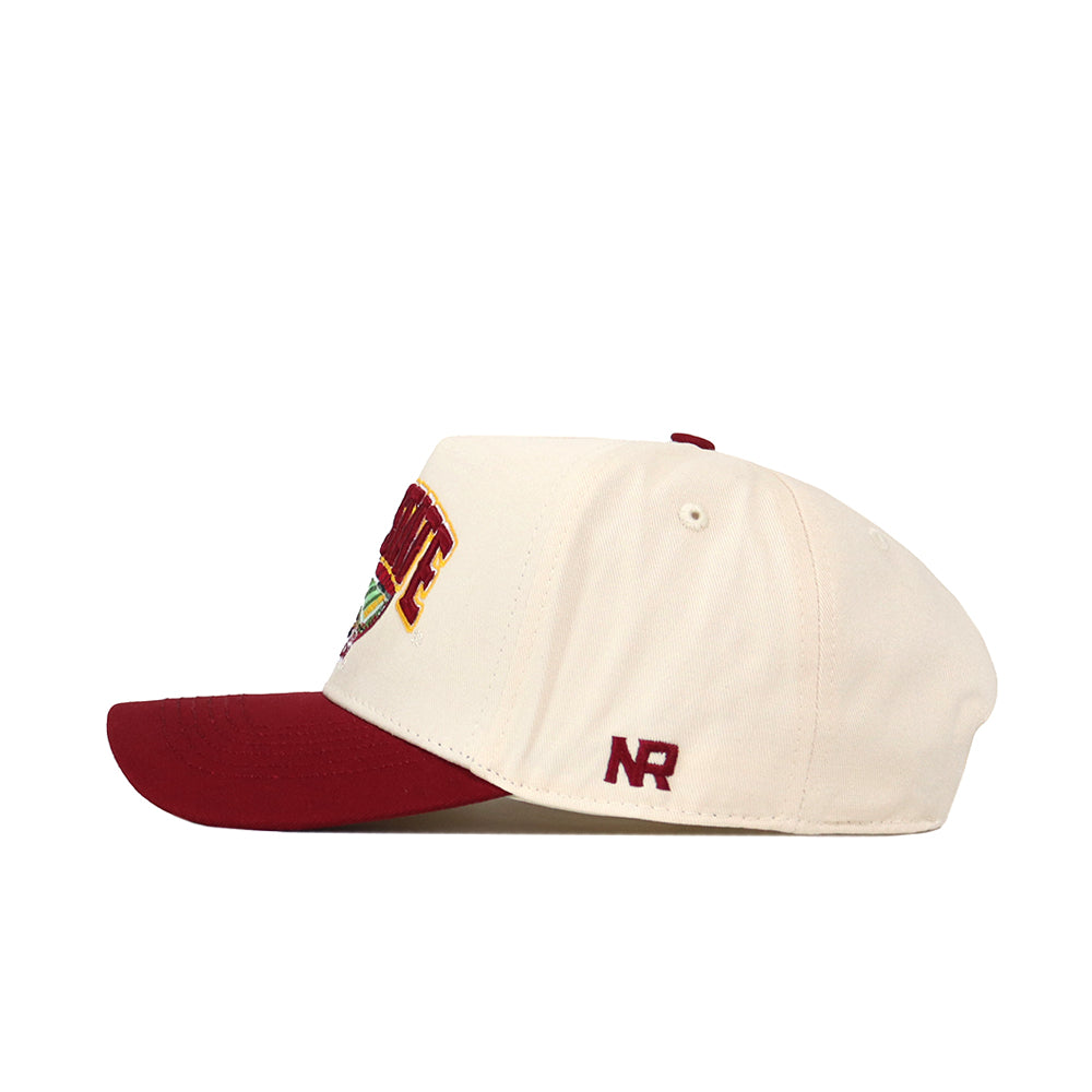The Iowa State Stadium Hat by No Rivals is a cream and maroon snapback crafted from premium cotton, featuring embroidered NR letters on the side and partially visible text across the front. The cap includes a maroon visor, matching top button, and bold embroidered graphics for a standout finish.