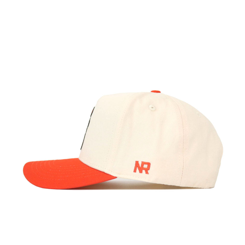 The No Rivals OSU Full Pistol Pete Patch Hat is a cream-colored snapback with a red brim and embroidered small red NR logo on the side, crafted from high-quality cotton. Shown in a structured fit side profile against a white background.