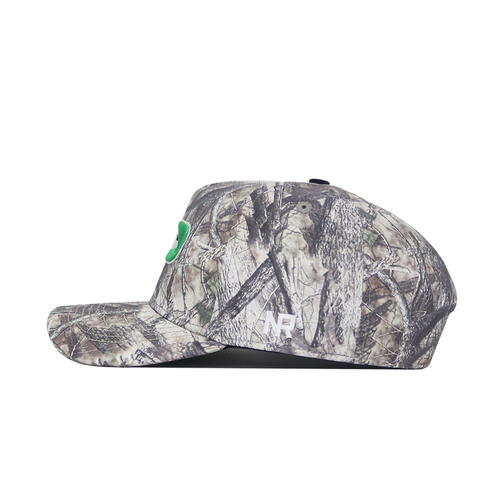 A side view of the North Dakota Outland Hat by No Rivals, a camouflage snapback cap with a small green emblem on the front and white "WP" initials on the side. Made from high-quality cotton for a comfortable, structured fit.