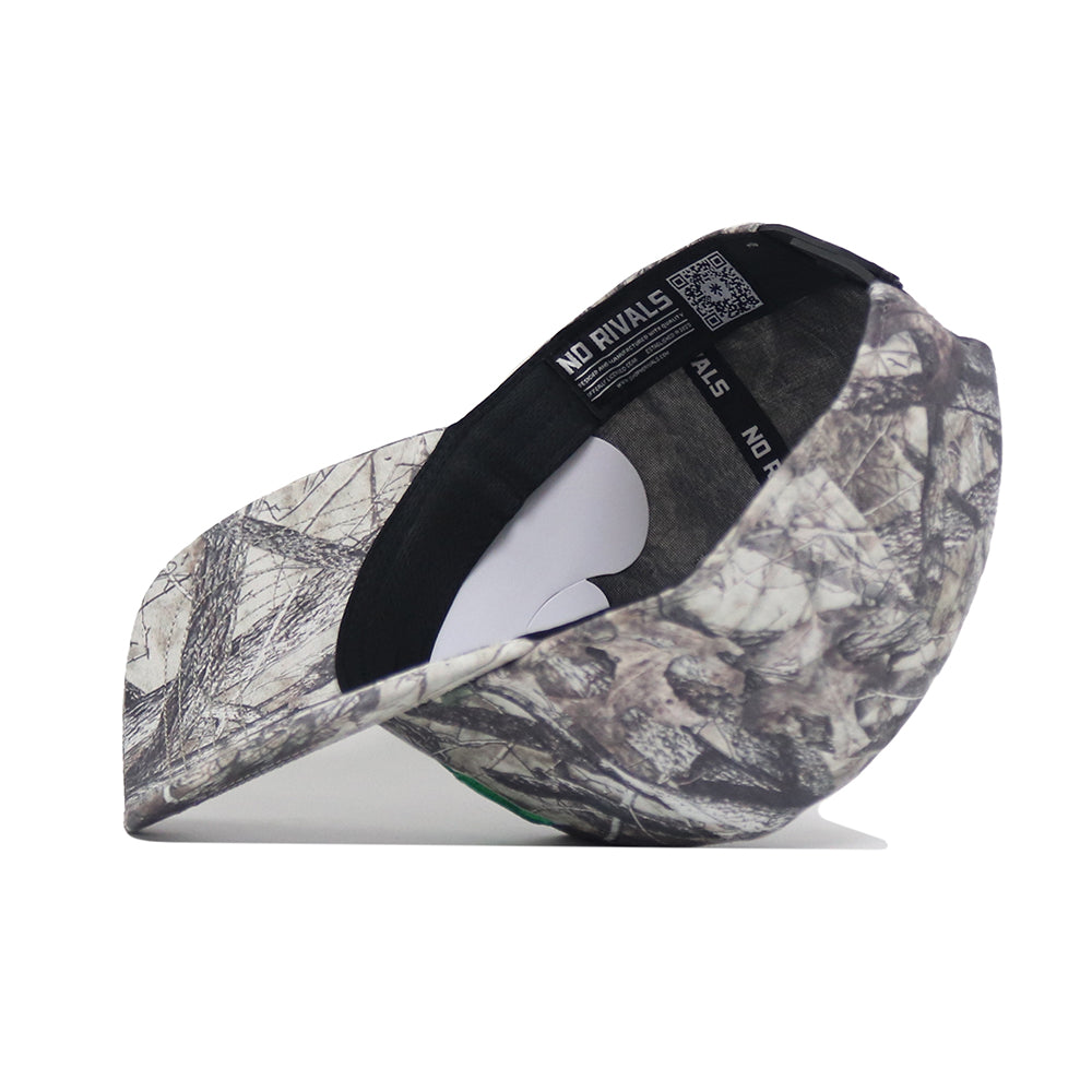 The No Rivals North Dakota Outland Hat is a structured, camouflage-patterned snapback baseball cap made from high-quality cotton. Shown side-on with brim down, it highlights the inside label and tags against a white background.