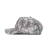 Side view of the Illinois Outland Hat by No Rivals in camouflage, featuring a small white logo on the side. Crafted from high-quality cotton, this snapback has a flat brim and structured crown for a comfortable fit.
